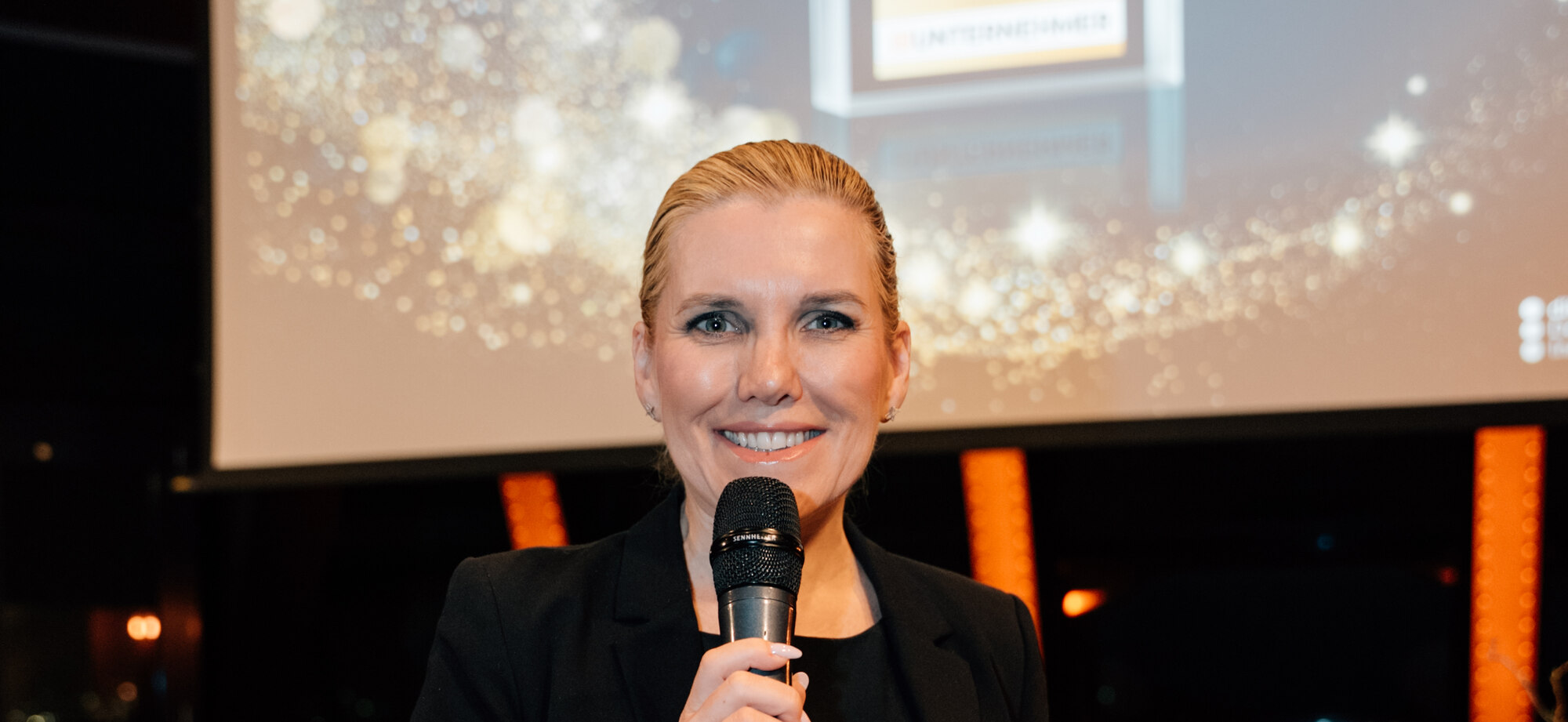 Dr. Tanja Hacker speaking at an award ceremony, recognized with the Unternehmen der Zukunft distinction